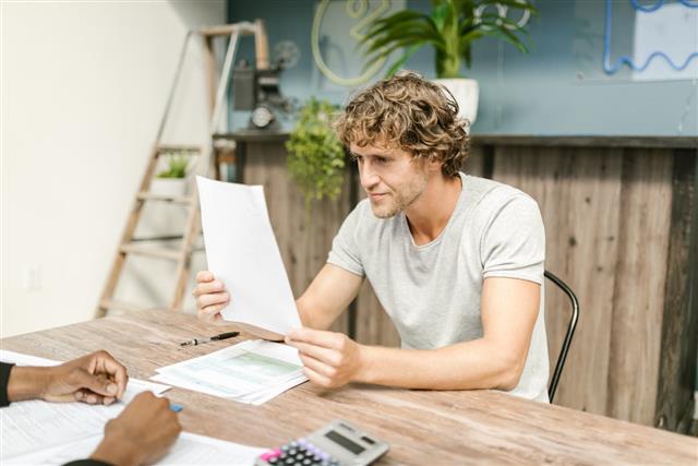 Senior reviewing financial and insurance paperwork at home